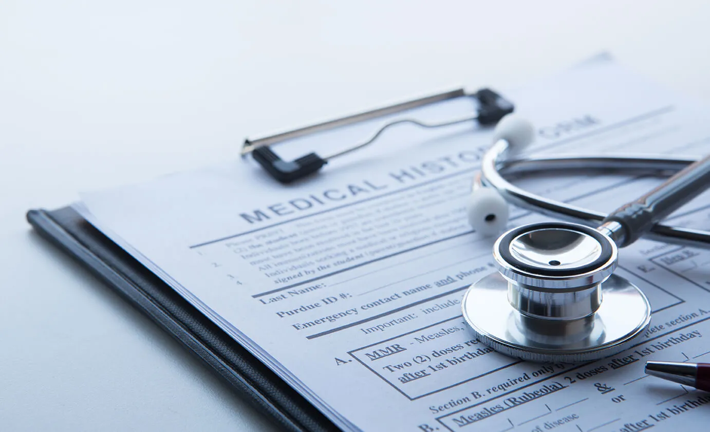 Stethoscope resting on a medical history form on a clipboard