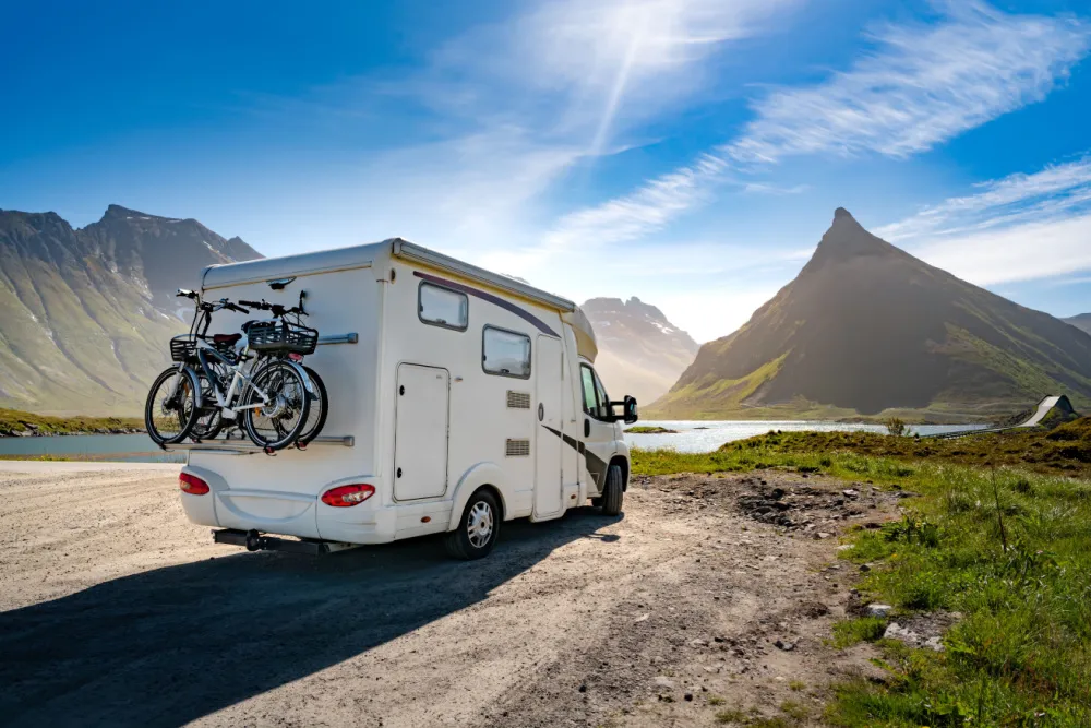 A recreational vehicle parked in a parking lot with a gas station in the background